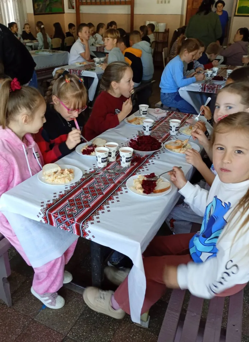 Учні обідають за столами в шкільній їдальні